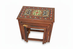 Wooden nesting tables with decorative paint on a white background