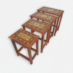 Set of four decorative wooden tables with intricate patterns on a white background